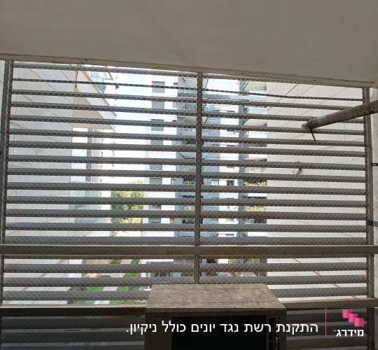 רשת מתכת על חלון למניעת כניסת יונים